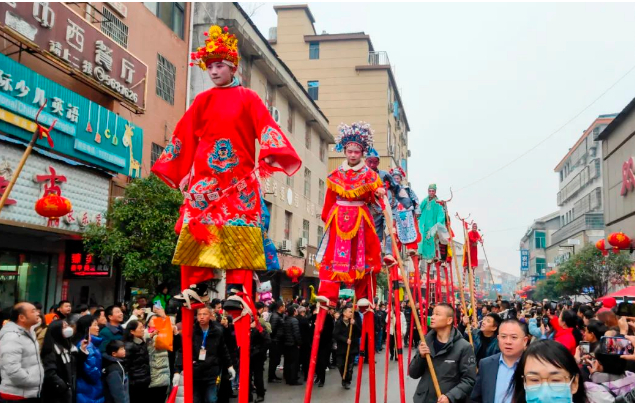 踩高跷是岳阳市汨罗长乐古镇抬阁故事会的民间特色表演艺术，吸引游客驻足观看。（胡清/图）