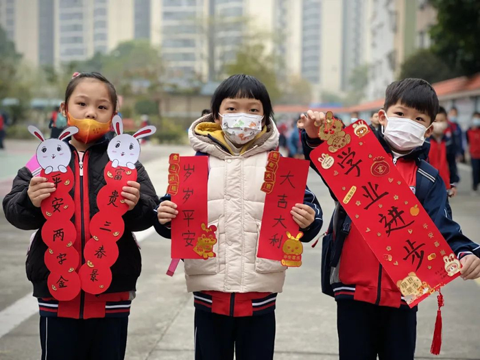 新民小学的小朋友带着自己亲手制作的兔年创意挥春回到熟悉的校园。