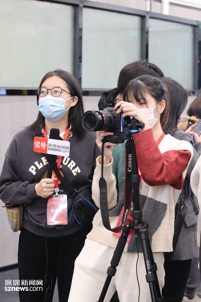 深圳新闻网记者赵文硕（左）翁任莹在等待皇岗口岸首位通关旅客的出现。（张玲 摄）