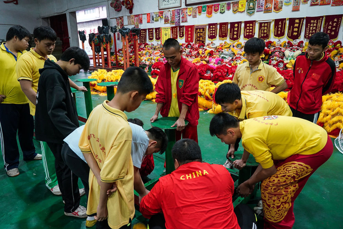 　　↑2023年1月13日，在南海大沥黄飞鸿中联龙狮训练基地，一群来自广州市从化区练习醒狮的青少年跟随教练搭建高桩。