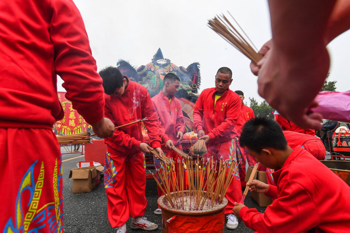 　　↑黄飞鸿狮艺武术馆师徒在西樵山牌坊燃点香火。