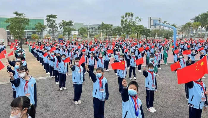 台山市都斛镇中心小学学生高举五星红旗。
