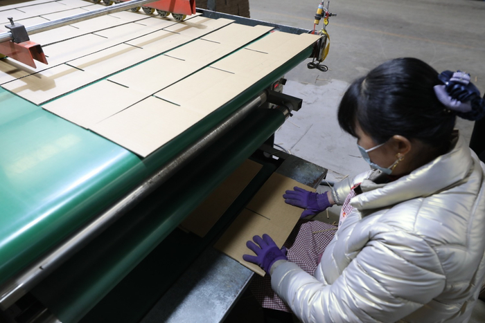 图为香河县佳胜凯利新型包装制品有限公司，工人在对半成品纸箱进行手工粘盒。