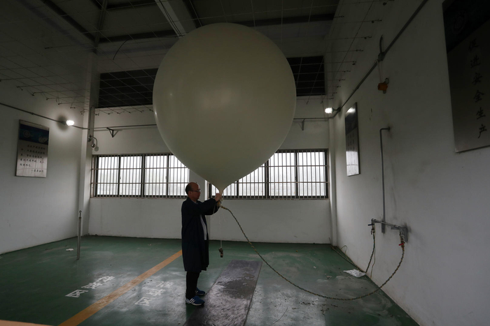 ↑2021年7月26日，上海市宝山区气象局的气象专家释放带有探空仪器的“探空气球”。图据IC photo