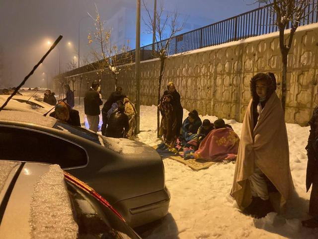 土耳其加济安泰普省，地震后人们在雪地中等待救援。图片来源：视觉中国