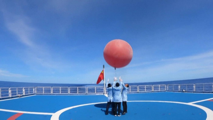 ↑研究人员释放探空气球预测天气情况。图据视觉中国