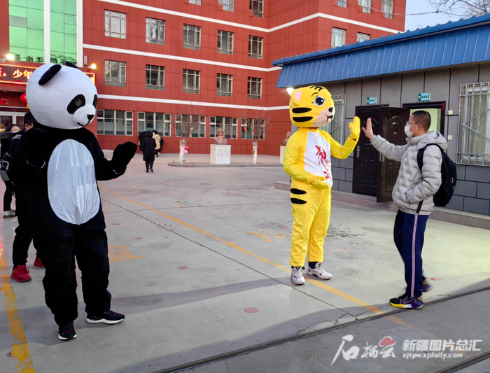 2月6日，哈密市第六中学校门口，老师身着卡通服饰迎接学生到来。通讯员叶翠摄
