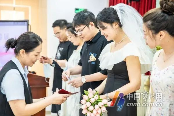 北仑民政局工作人员为新人颁发结婚证。