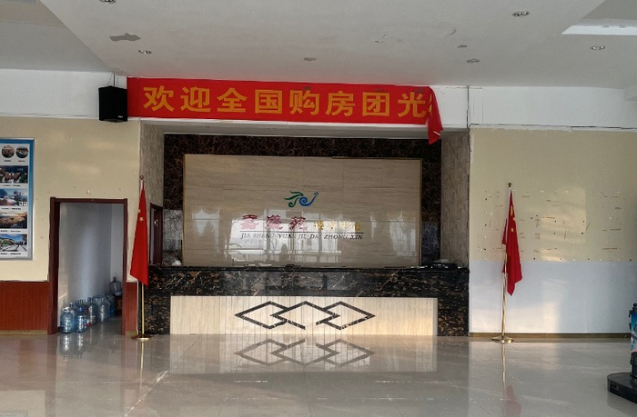 银滩一售楼处悬挂着“欢迎全国购房团光临”的横幅，时代周报记者摄