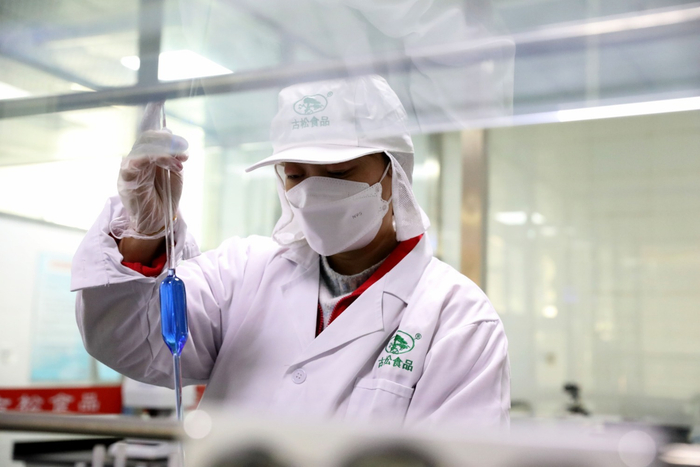 图为河北古松农副产品有限公司实验室内，技术人员正在检测糖的折光锤度。