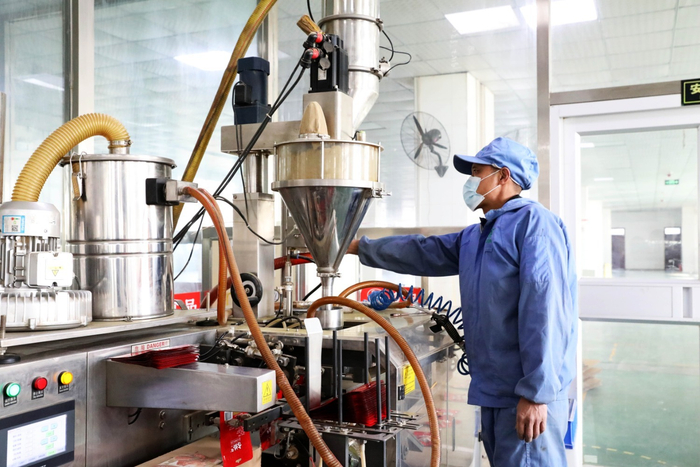 图为河北古松农副产品有限公司生产车间内，工作人员正在操作机器设备生产花椒粉调料。