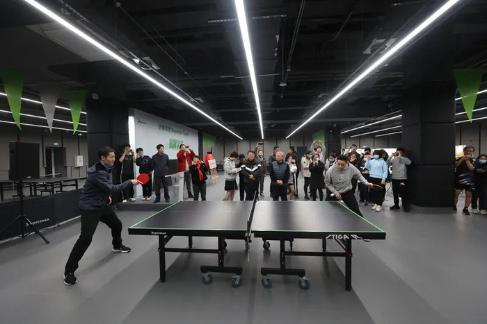 奥运冠军、中国乒乓球协会副主席王励勤（左）与许昕共同挥拍开球。