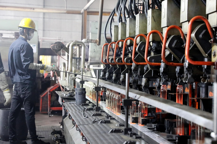 图为河北华兴玻璃有限公司生产车间内，一批最新的玻璃瓶在生产线上产出。