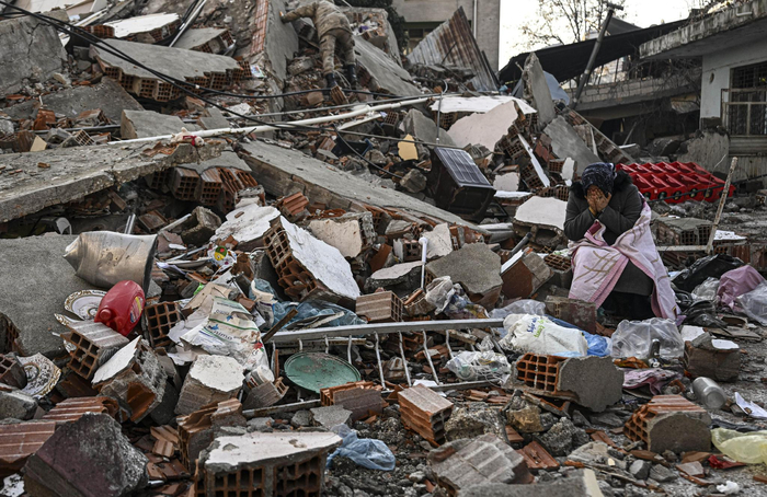 当地时间2023年2月9日，土耳其哈塔伊，地震发生后，一名妇女在废墟前落泪。图/ic