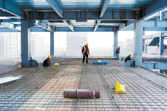 　　在北大附中石景山学校（新址）项目施工现场，工人进行钢筋绑扎、楼层板铺设作业。 石景山区融媒体中心供图