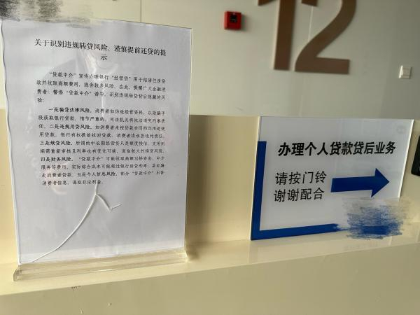 △某商业银行办理个人贷款贷后业务处，竖起了谨慎提前还贷的提示。