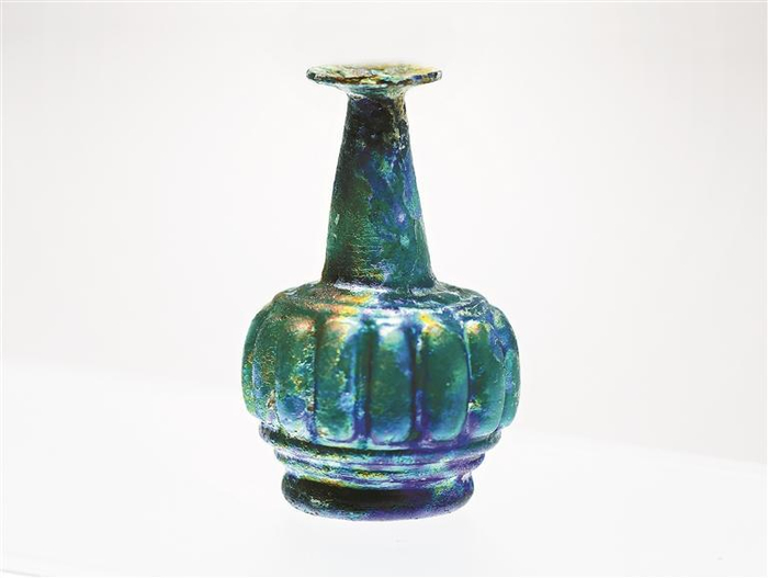 肋纹长颈瓶（公元9世纪~10世纪，伊朗），造型模仿金属器，表面因银化出现了多彩光泽。 