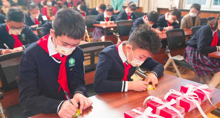 2月13日，在北京市东城区黑芝麻胡同小学，同学们在卡片上写上新学期心愿，准备贴在“班级树”上。（受访对象供图）