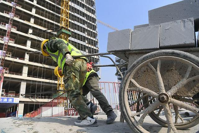 施工人员正在向楼内搬运建筑材料。新京报记者 王颖 摄