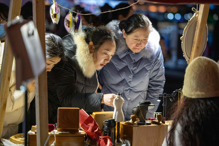 2月15日，游客在宁波老外滩步行街夜集市上挑选饰品。新华社记者 江汉 摄