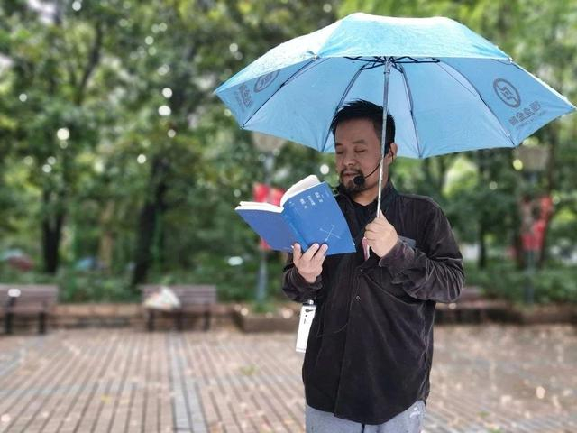 突降大雨，曹再飞借了把蓝色的伞，正好泰戈尔的《假如我今生无缘遇到你》诗集也是蓝色的。受访者供图