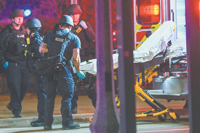     2月13日，在密歇根州立大学外，救援人员取出担架车。新华社发