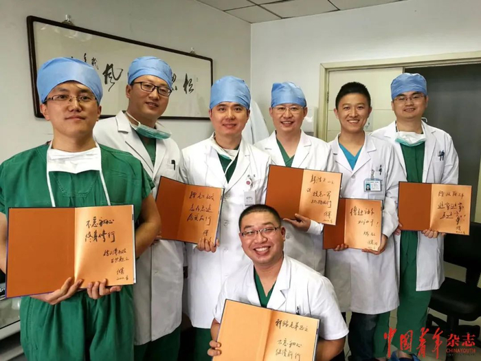 张骞（左三）向进修医生赠送他主编的《泌尿外科腹腔镜手术——操作技术与要领》一书