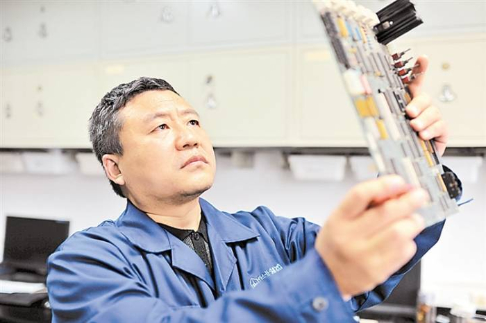 齐名在认真查找电路板故障。河北日报资料片
