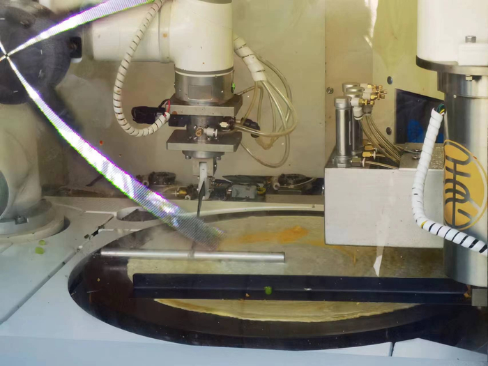 摊煎饼的每一个步骤，机器人都做得有条不紊。