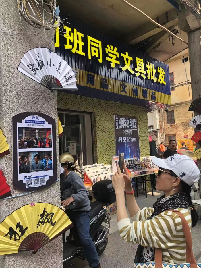 △游客在“强盛小灵通”店前留影。