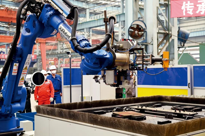 　　江南造船的吊马智能工作站里，机器人正在进行焊接。据介绍，这个智能工作站中，除装配工序外，搬运、焊接、打磨、下料等工序全部由机器人完成，首次在船舶行业内集成了机器人视觉识别、智能抓取、智能焊接技术，是目前行业内最先进的船用吊马生产线，它的投入使用将大大减少人工需求，将原来的27人团队压缩至5人，且能够保持吊马生产质量的稳定性。图/江南造船集团提供