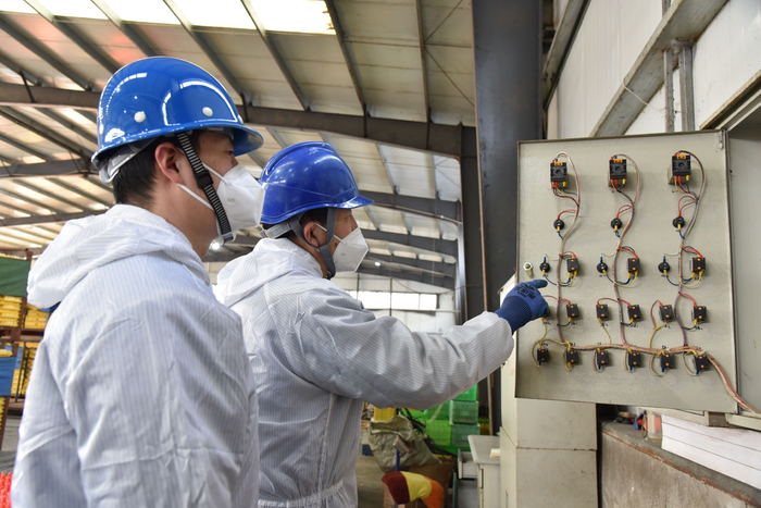 　　香河供电公司员工孙树清、周兴华正在香河县新恒昌养鸡场为客户检查配电箱 （王储）