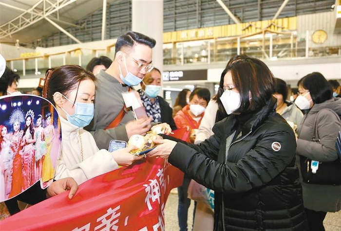 长龙航空工作人员在西安咸阳国际机场为前往曼谷的旅客赠送纪念品 首席记者 李明 摄