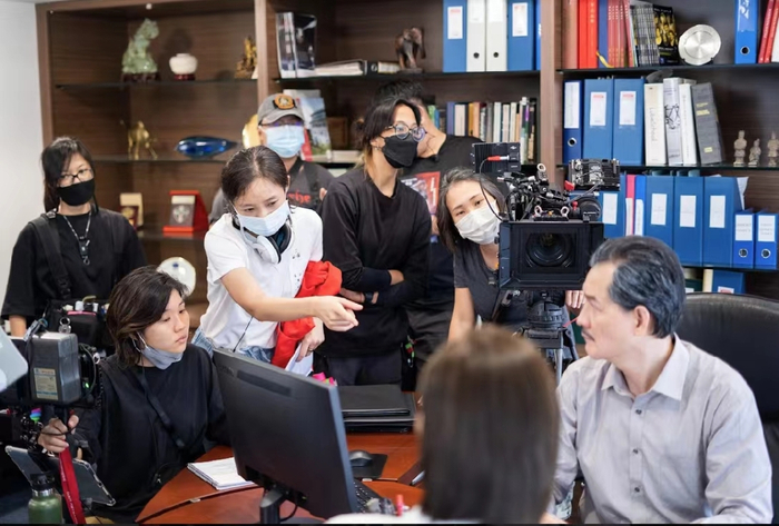 吴可嘉（白衣服）与团队工作人员正在拍摄中。受访者供图