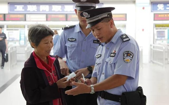 2018年,杨仁德在福州站自动售票机旁教旅客购票 。南昌铁路公安局福州公安处供图