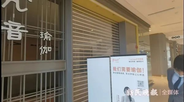 凯德晶萃广场物业已派人（图中打领带者）到该店门口值守，非经同意，店内物品不能拿出  新民晚报记者  罗水元  摄