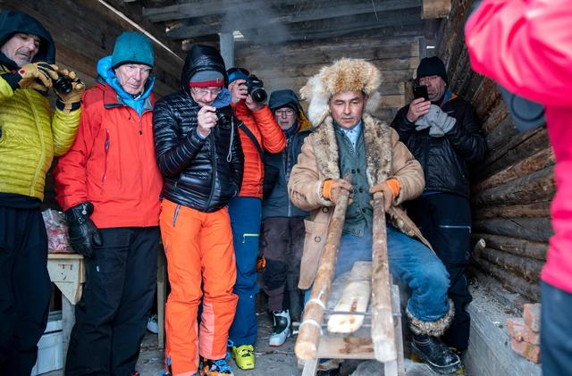 来自欧洲的雪友在新疆阿勒泰地区禾木村观看牧民制作古老毛皮滑雪板（2019年1月10日摄）。新华社记者 胡虎虎 摄