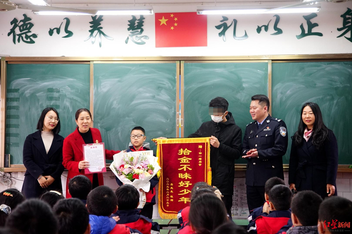 ↑民警和失主给钟一瑁送来锦旗、鲜花