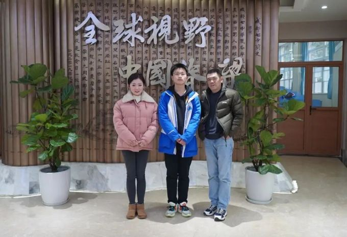 ▲高2021级13班饶轶琨（中）与班主任郑文书（右）、指导老师徐珂（左）合影