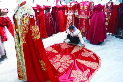     丁集镇一家婚纱店内，工作人员正在整理中式婚服。新华社记者张端/摄