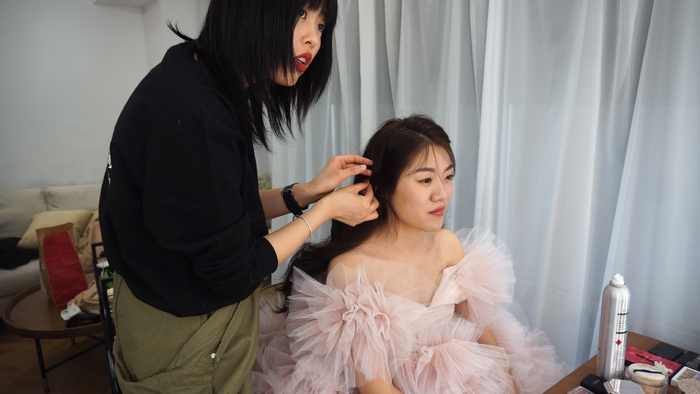 拍摄婚纱照前，化妆师为新人化妆