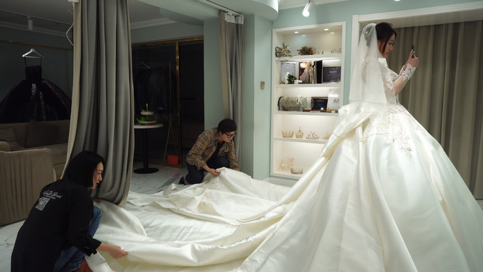 帮助新人试穿婚纱