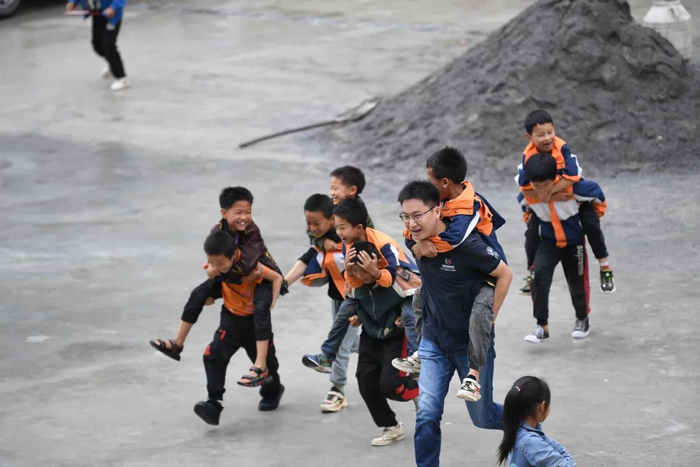 志愿者郭子鸣和为民小学二年级学生玩耍