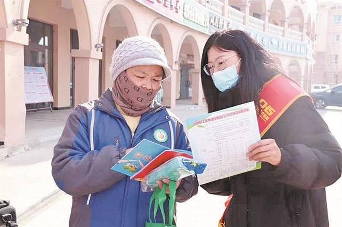     2月27日，四师可克达拉市医保中心工作人员（右）为居民讲解兵团异地就医直接结算政策。赵青霞  摄