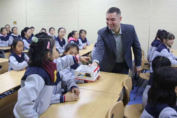 　　德国文化课堂上德科斯米尔沈阳内饰工厂厂长向孩子们发放德国糖果