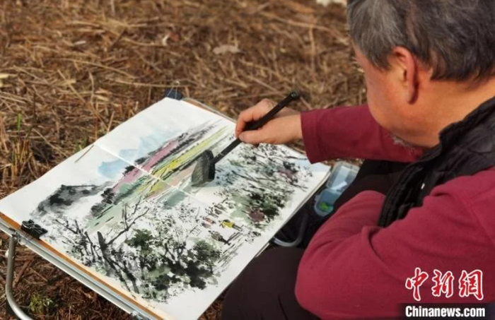 图为台湾知名画家李沃源在贵安樱花园内写生。　周燕玲 摄