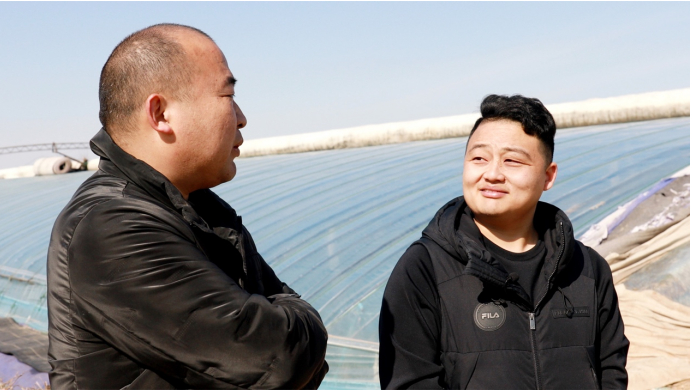 ▲瓜棚外，刘存良（左）谈起与拼多多卖家赵林（右）的合作，依旧记得当初的那份震惊。周欣悦/摄