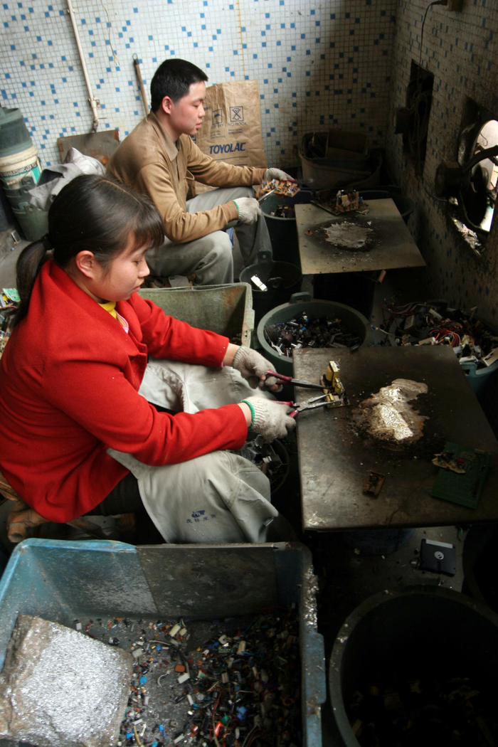 ↑20年前，贵屿拆解户正在手工烧板 图据赖芸