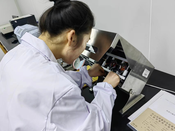 舟山市质量技术监督检测研究院工作人员在对老视镜样品进行检测。