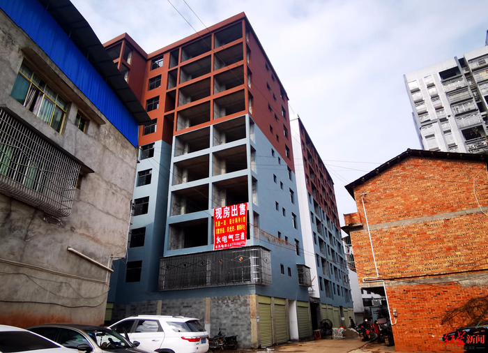 ↑大楼上，悬挂后“现房出售”的广告